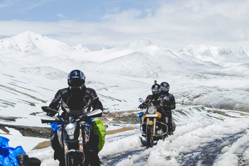 Adventure motorcycles on a snowy pass in the Himalayas.