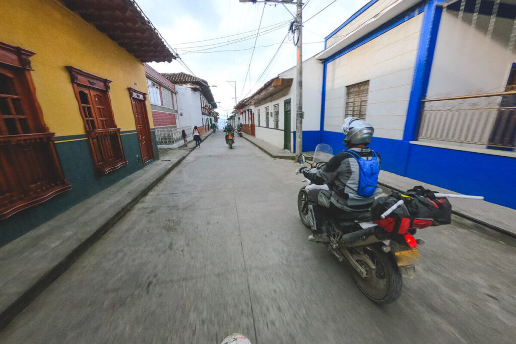 Adv riders riding through a village in Colombia.